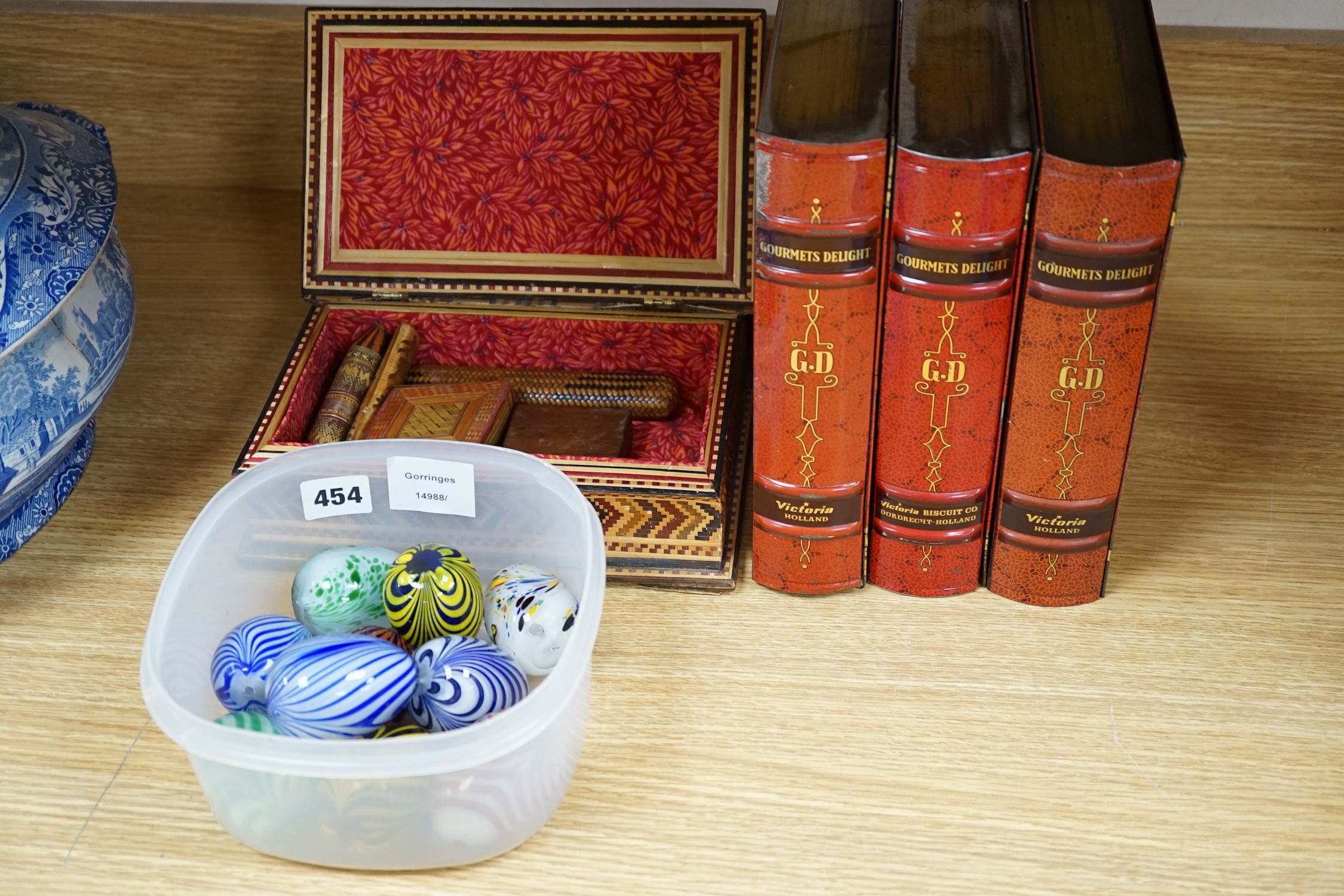 Sundry items to include glass eggs, marbles, a set of three tins in the form of books and a straw work box, etc. Condition - mostly fair